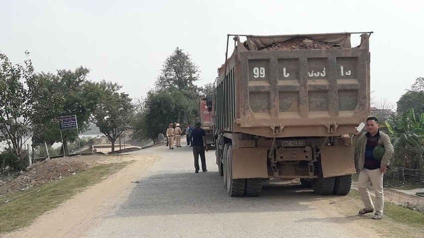 Trên đê, lực lượng CSGT đang kiểm tra các xe chở đất.