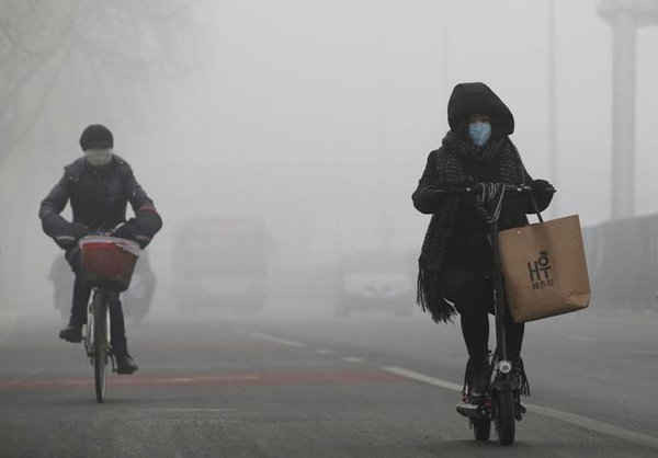 Mọi người đi xe trong sương mù ở Bắc Kinh, Trung Quốc vào ngày 14/2/2017. Ảnh: REUTERS / Jason Lee
