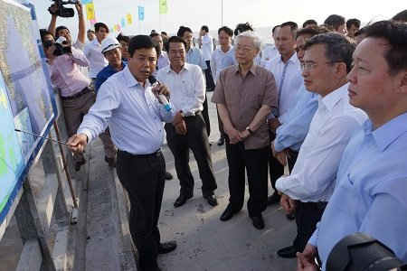 Tổng bí thư Nguyễn Phú Trọng nghe Chủ tịch UBND tỉnh Cà Mau Nguyễn Tiến Hải báo cáo tình hình xây dựng cầu cảng Hòn Khoai và khu điện gió Khai Long.