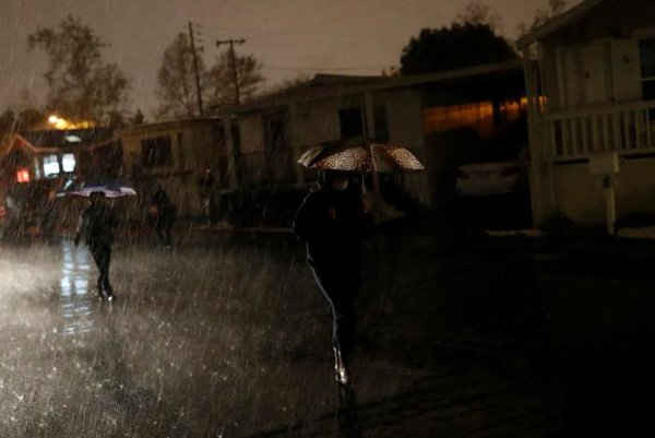 Người phụ nữ đi trong mưa trong khu nhà di động ở thành phố San Jose - phía nam vùng vịnh San Francisco, California, Mỹ vào ngày 21/2/2017. Ảnh: REUTERS / Stephen Lam