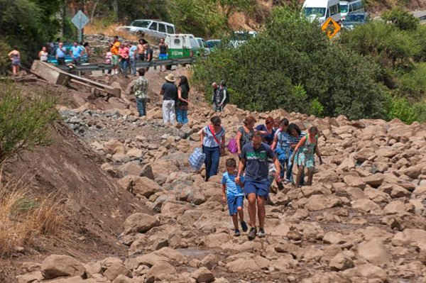 Người dân đi bộ trên con đường bị hư hại sau khi lũ lụt tấn công gần Santiago, Chile ngày vào ngày 26/2/2017. Ảnh: REUTERS / Stringer