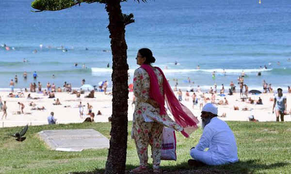 Hai người trú nắng ở bãi biển Bondi của Sydney, Australia. Ảnh: William West / AFP / Getty