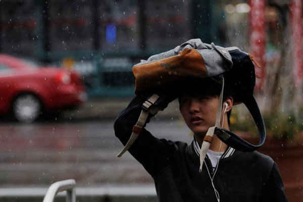 Một người đàn ông sử dụng ba lô để che mưa ở New York, Mỹ vào ngày 1/3/2017. Ảnh: REUTERS / Lucas Jackson