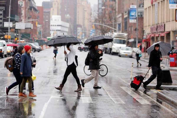 Những người đi bộ băng qua đường trong cơn mưa ở New York, Mỹ vào ngày 1/3/2017. Ảnh: REUTERS / Lucas Jackson