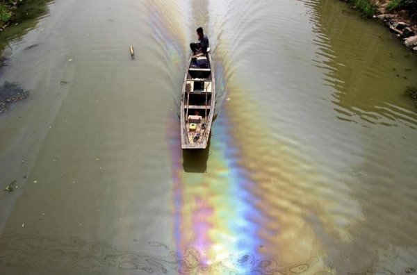Một người đàn ông lái thuyền trên con sông bị ô nhiễm do nhiên liệu bị rò rỉ, ở Thiệu Hưng, tỉnh Chiết Giang, Trung Quốc vào ngày 29/4/2015. Ảnh: REUTERS / Stringer