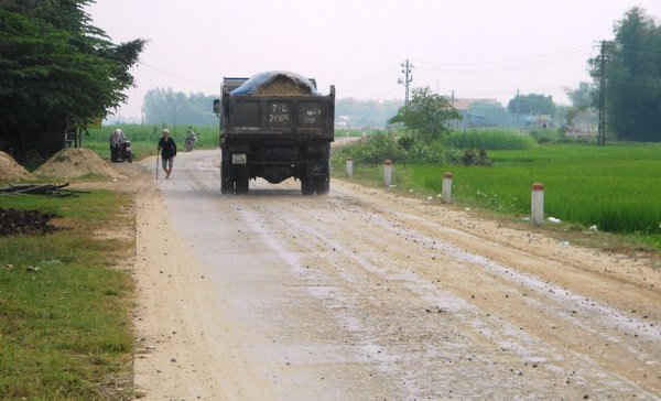 Mặt đường tỉnh lộ 636B qua thôn Hiếu An, xã Nhơ Khách (TX An Nhơn) trở nên dơ bẩn bởi xe chở cát.