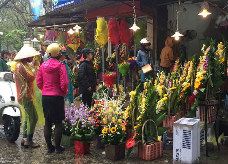 Mặc dù trời mưa phùn ẩm ướt nhưng từ sáng sớm ngày 7/3 các cửa hàng hoa trên phố Nguyễn Qúy Đức đã rất đông khách đến mua hàng