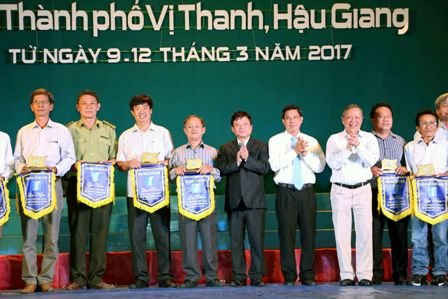 lãnh đạo UBND tỉnh Hậu Giang và Hội nhạc sĩ Việt Nam tặng cờ lưu niệm cho các đội tham dự liên hoan âm nhạc.