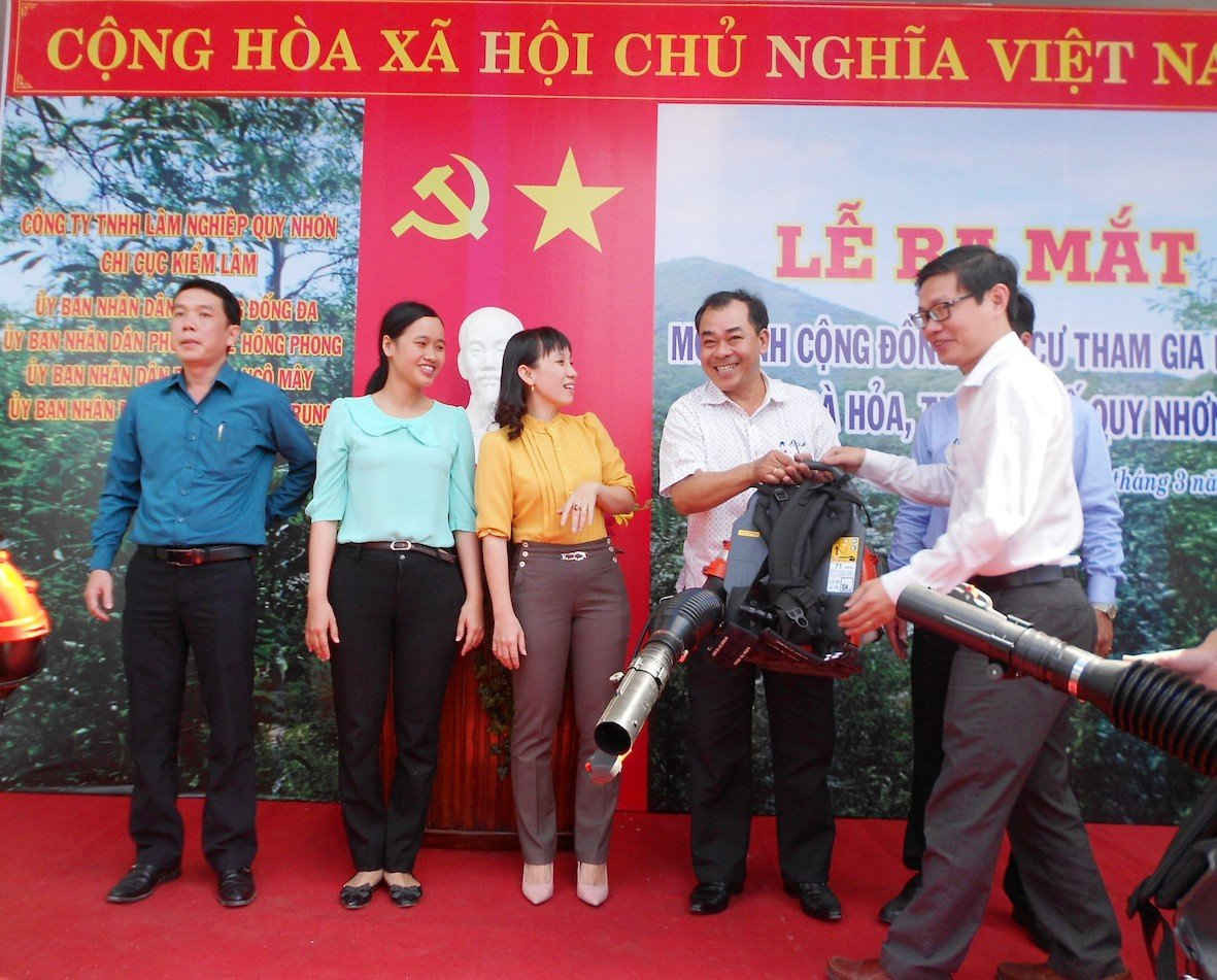 Ông Lê Anh Sơn, Phó Chủ tịch UBND TP Quy Nhơn (phải) trao máy thổi gió cho tổ PCCCR núi Bà Hỏa.