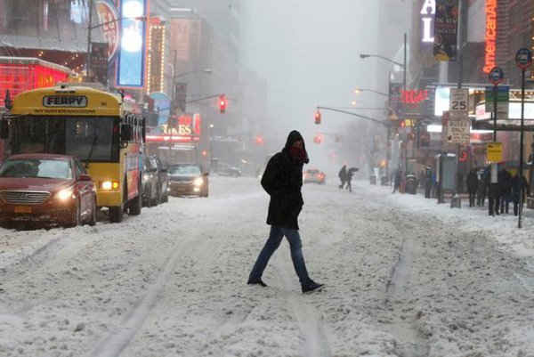 Một người đi bộ qua đường trong cơn bão tuyết ở Quảng trường Thời đại ở Manhattan, New York. Ảnh: REUTERS / Carlo Allegri