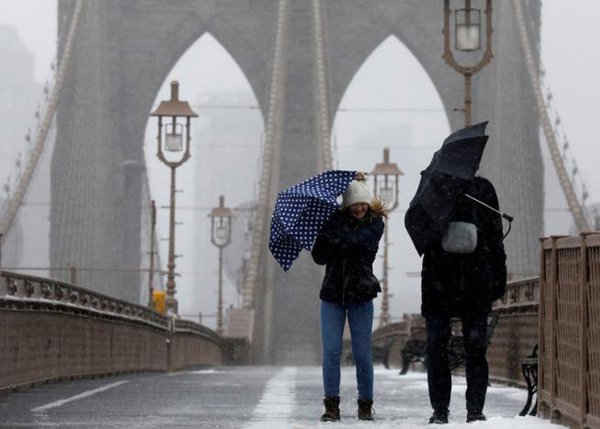 Mọi người chống chọi với gió và tuyết khi họ đi bộ qua cầu Brooklyn ở thành phố New York. Ảnh: REUTERS / Brendan McDermid