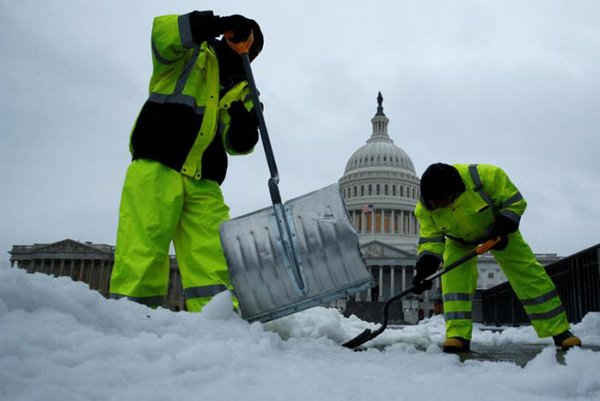 Công nhân dọn dẹp lượng tuyết dày trên lối đi bộ tại Tòa nhà Quốc hội Mỹ ở Washington. Ảnh: REUTERS / Jonathan Ernst