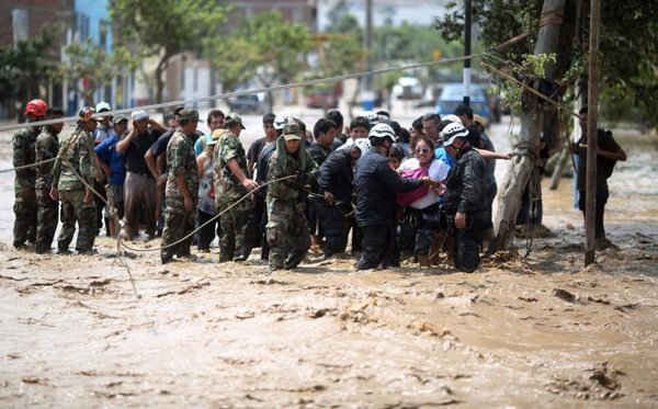 Cảnh sát giúp người dân vượt qua một con đường bị ngập lụt sau trận lở đất và lũ lụt dữ dội ở quận Huachipa thuộc Lima, Peru vào ngày 17/3/2017. Ảnh: REUTERS / Sebastian Castaneda