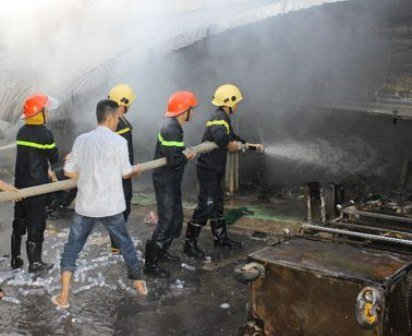 Lực lượng cảnh sát phòng cháy chữa cháy đang  phun xịt nước để dập tắt đám cháy tại chợ Vị Thắng.