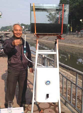 Giáo sư Trần Hồng Côn bên chiếc máy lọc nước sông Tô Lịch thành nước sạch. Ảnh VnExpress