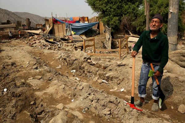 Ông Leon Mendoza đứng bên cạnh ngôi nhà bị phá hủy của ông sau khi các con sông vỡ bờ do mưa xối xả, gây ngập lụt và phá hủy trên diện rộng ở Huachipa, Lima, Peru vào ngày 26/3/2017. Ảnh: REUTERS / Mariana Bazo