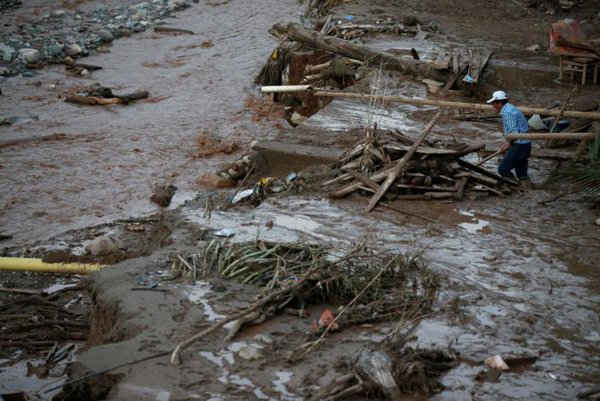 Người đàn ông tìm kiếm đồ đạc của mình sau trận mưa lớn khiến một số dòng sông tràn bờ, trầm tích và đá bị cuốn trôi vào các tòa nhà và các con đường tại Mocoa, Colombia vào ngày 1/4/2017. Ảnh: REUTERS / Jaime Saldarriaga