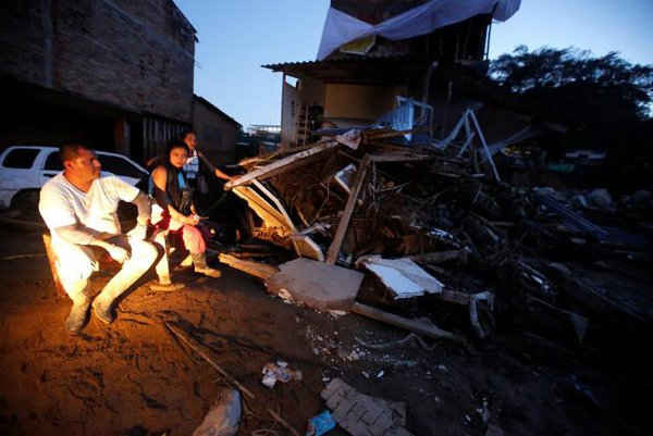 Một gia đình ngồi bên ngoài ngôi nhà bị phá hủy của họ sau trận mưa lớn khiến một số dòng sông tràn bờ, trầm tích và đá bị cuốn trôi vào các tòa nhà và các con đường tại Mocoa, Colombia vào ngày 1/4/2017. Ảnh: REUTERS / Jaime Saldarriaga