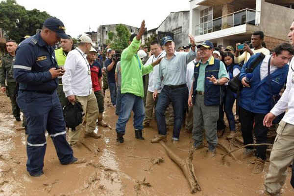 Tổng thống Colombia Juan Manuel Santos (hàng đầu tiên, thứ tư từ trái sang) thăm khu vực bị ngập lụt sau sau trận mưa lớn khiến một số dòng sông tràn bờ, trầm tích và đá bị cuốn trôi vào các tòa nhà và các con đường tại Mocoa, Colombia vào ngày 1/4/2017. Ảnh: Cesar Carrion
