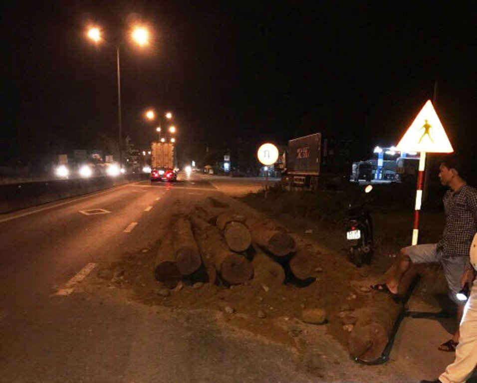 Số gỗ trên xe tải ben đỗ xuống mặt đường quốc lộ 1A