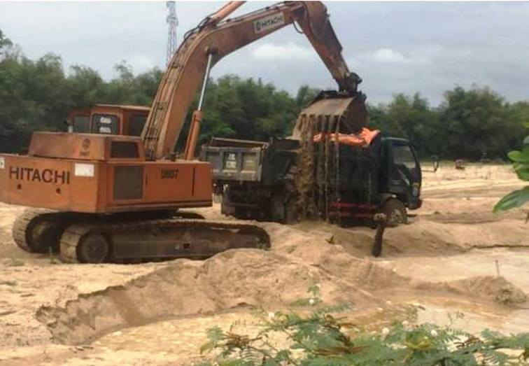 Xe đào xúc cát tại sông La Tinh đoạn chảy qua thôn Vạn Thái, xã Mỹ Tài (huyện Phù Mỹ) đưa lên xe ben chở đi tiêu thụ.