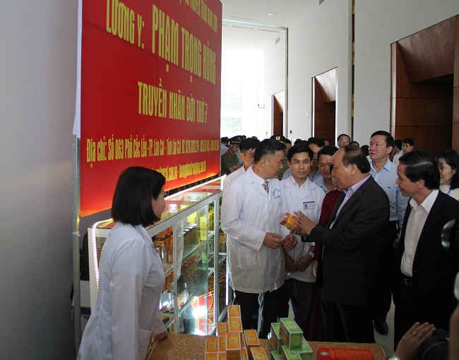 Thủ tướng Chính phủ Nguyễn Xuân Phúc đi thăm quan và chụp ảnh lưu liệm với các gian hàng trưng bày sản phẩm dược liệu