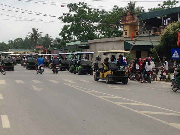 Hàng chục chiếc xe điện nối đuôi nhau kéo dài trên đường phố Sầm Sơn gây cản trở giao thông.