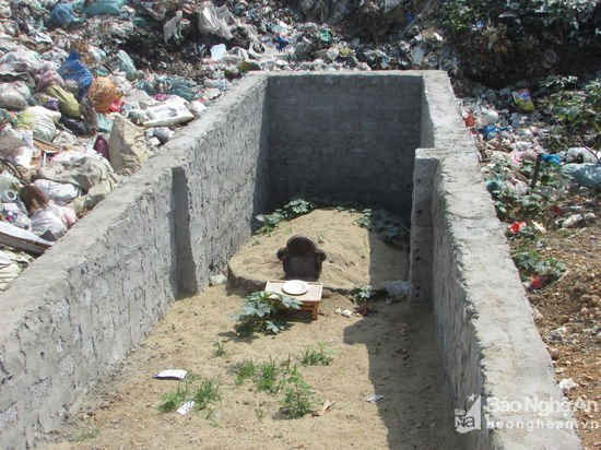 Một ngôi mộ vừa được bới tìm sau khi bị rác thải vùi lấp. Hiện ngôi mộ đã được xây kè chống tình trạng rác thải tái sạt lở.