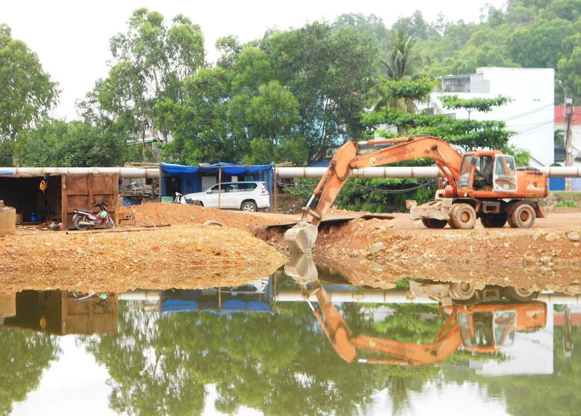 Công ty TNHH Phúc Lộc cho xe đổ đất, cát chặn dòng nhánh sông Hà Thanh để thi công cầu Điện Biên Phủ khiến khiến dòng chảy bị gián đoạn.