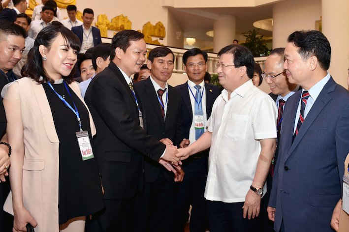 Phó Thủ tướng Trịnh Đình Dũng, Bộ trưởng Bộ TN&MT Trần Hồng Hà trò chuyện với các DN ứng dụng công nghệ thân thiện môi trường. Ảnh: VGP/Nhật Bắc