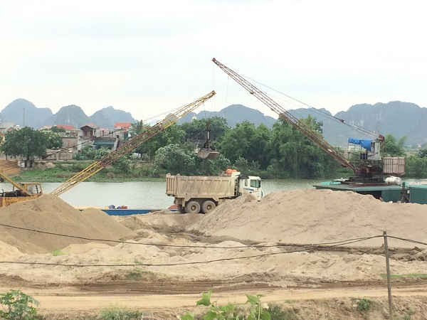 Rất nhiều các xe vận chuyển và tàu thuyền cát chực chờ lấy hàng và bán hàng tại bãi cát hộ ông Nguyễn Văn Khiêm tại xã Gia Phú