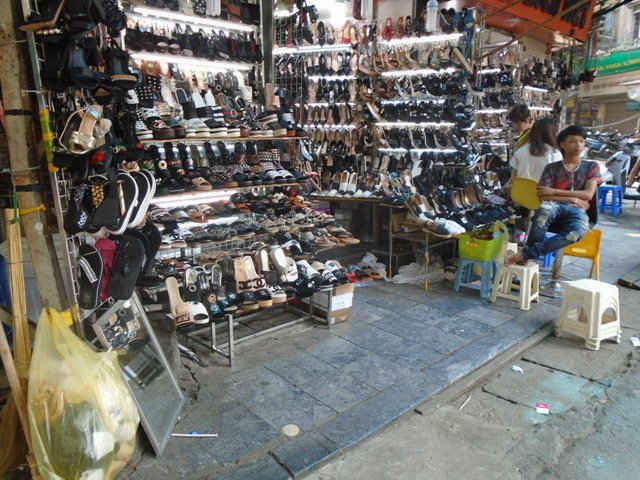 Quán bán giầy dép cũng trưng dụng vỉa hè để bày bán sản phẩm