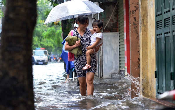 Mưa lớn vào sáng sớm gây ngập úng các bậc phụ huynh bì bõm đưa các em tới trường