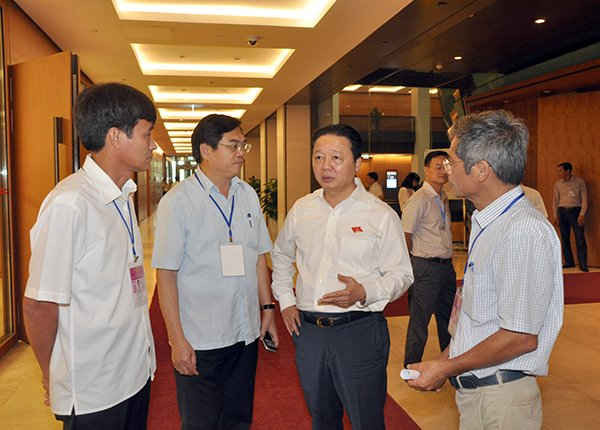 Bộ trưởng Trần Hồng Hà trao đổi với lannhx đạo các đơn vị trực thuộc Bộ TN&MT bên hành lang Quốc hội sáng 15/6. Ảnh: Việt Hùng