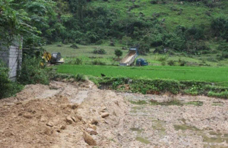 Đất, đá do Cty TNHH MTV Na Ni Sa khai thác quặng quarzit vùi lấp ruộng của dân. Ảnh: Quang Minh