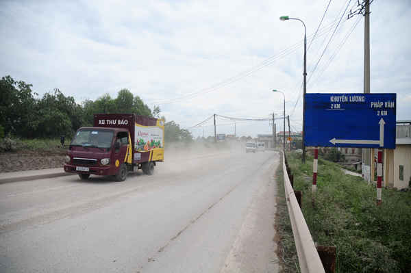 Những chiếc xe tải cuốn bùn đất ra đường đê Nguyễn Khoái gây bụi bay vào nhà người dân