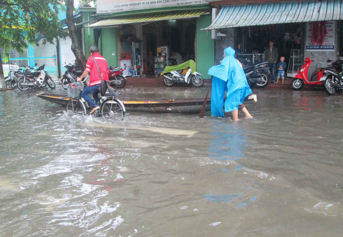 Đường phố Huế trong một lần ngập lụt khiến người dân phải vất vả di chuyển