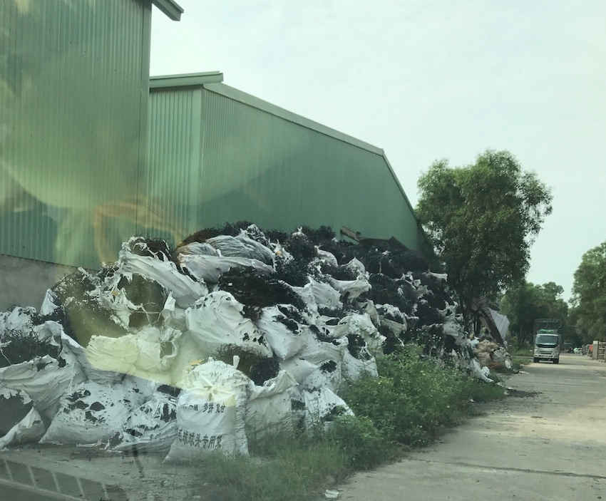 Bên ngoài xưởng chất đống nhựa phế thải không tận dụng được