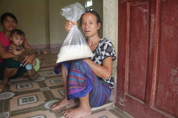 Bà Lô Thi Quyên, trú tại bản Huôi Muống, xã Tiền Phong với ít gạo đi vay mượn được.