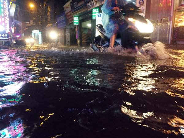 Tại phố Triều Khúc ngập sâu trong nước, các phượng tiện lưu thông qua khu vực gặp rất nhiều khó khăn