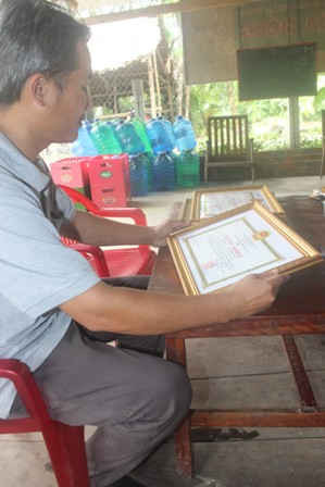  Anh Trần Minh Hùng, bên tấm bằng khen mà Chủ tịch UBND tỉnh Hậu Giang tặng gia đình anh vì đã có thành tích xuất sắc, tiêu biểu trong phong trào thi đua yêu nước gắn với thực hiện việc 
