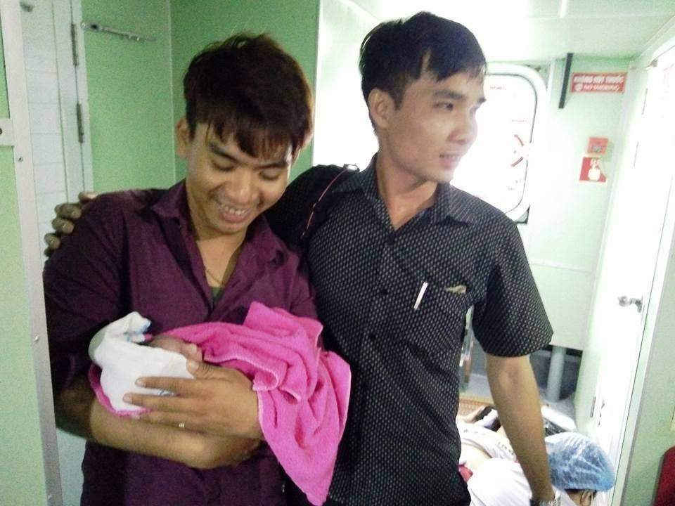 Sinh viên Nguyễn Thanh Hiền (bên phải) chia sẻ niềm vui với người chồng chị Thảo chê tàu sau khi đỡ đẻ thành công chiều ngày 19-7.