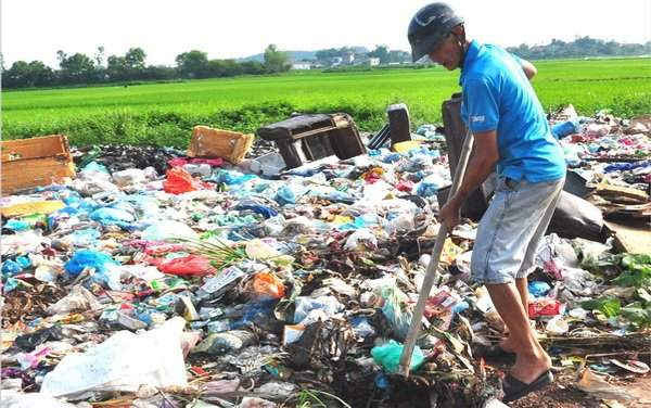 Ông Nguyễn Văn Hào thu dọn rác tại bãi rác thôn Biềng, xã Cao Thượng.