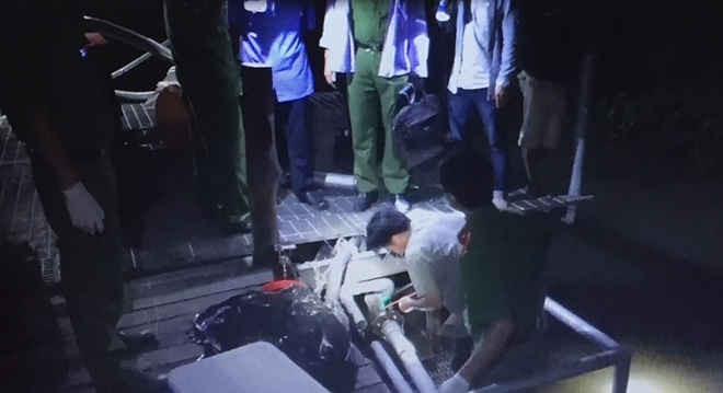 Lực lượng cảnh sát phòng chống tội phạm về môi trường thu mẫu nước xả thải tại Công ty Huy Việt - Tây Đô, đêm 12/7. 