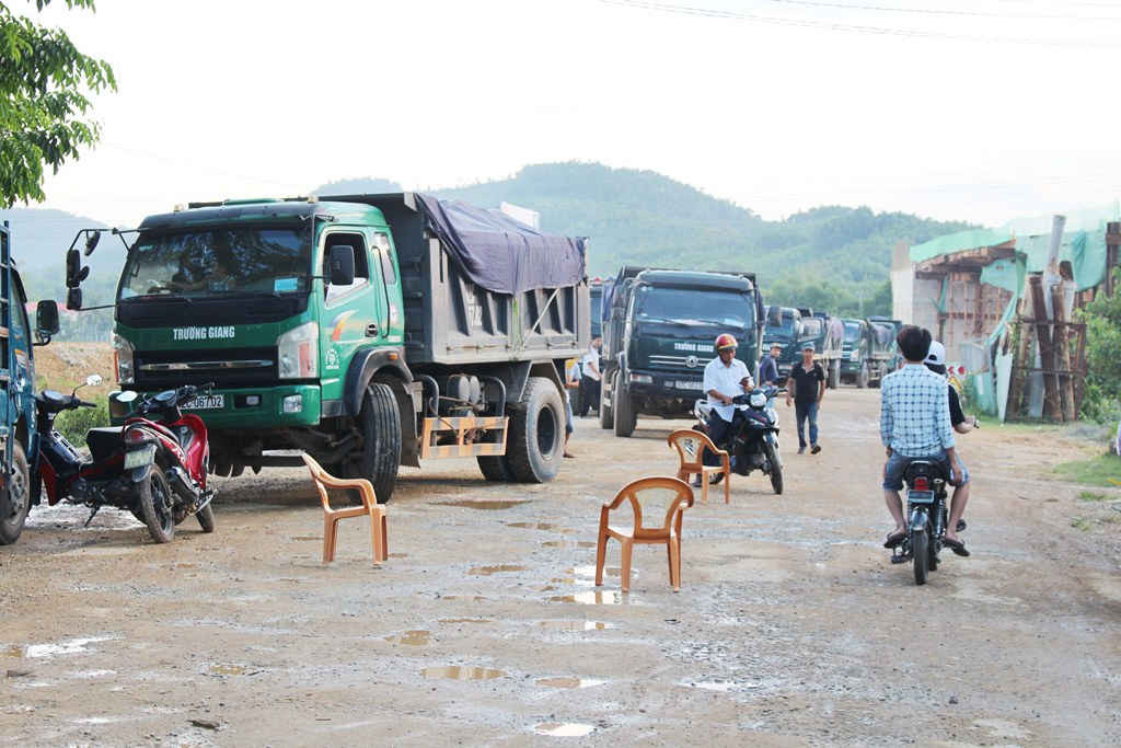 Dân dùng các chiếc ghế làm vật cản chặn xe tải chở đất gây bụi