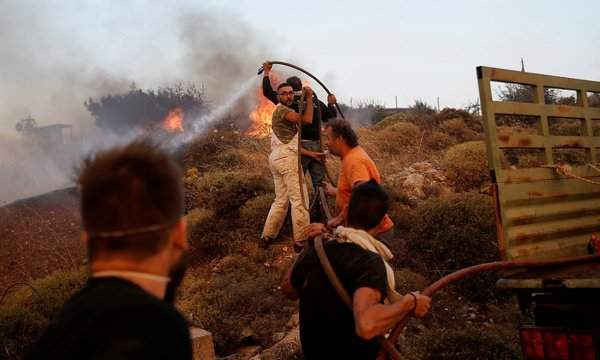 Mọi người cố gắng dập tắt ngọn lửa từ vụ cháy rừng gần ngôi làng Varnavas, phía Bắc Athens. Ảnh: Alkis Konstantinidis / Reuters