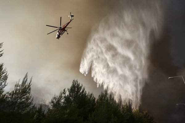 Một chiếc trực thăng xả nước xuống đám cháy rừng ở làng Kalamos, phía Bắc Athens. Ảnh: Yorgos Karahalis / AP