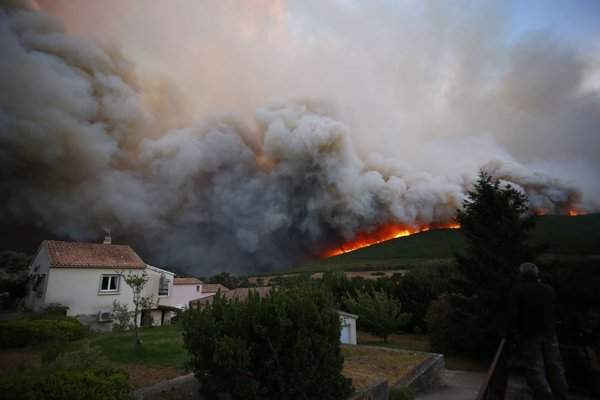 Mọi người nhìn lửa cháy rừng ở xã Pietracorbara trên đảo Corsica, Pháp. Hình ảnh: Pascal Pochard-Casabianca / AFP / Getty