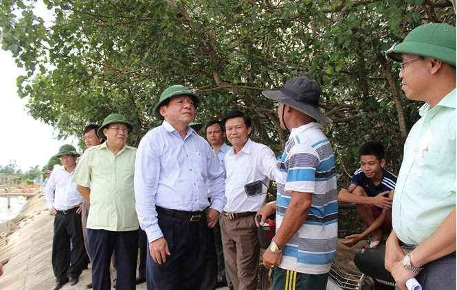 Bí thư Tỉnh ủy Quảng Trị Nguyễn Văn Hùng( đội mũ cối đứng giữa) lắng nghe bức xúc của người dân về tình trạng Cty Duy Tân hút cát bỏ bùn