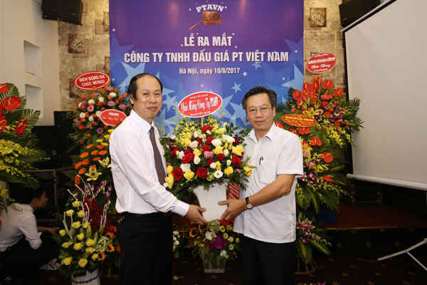 Ông Nguyễn Minh Tuấn, TGĐ Công ty đấu giá PT Việt Nam nhận lẵng hoa chúc mừng của ông Trần Ngọc Quang, nguyên Tổng thư ký HH BĐS VN.